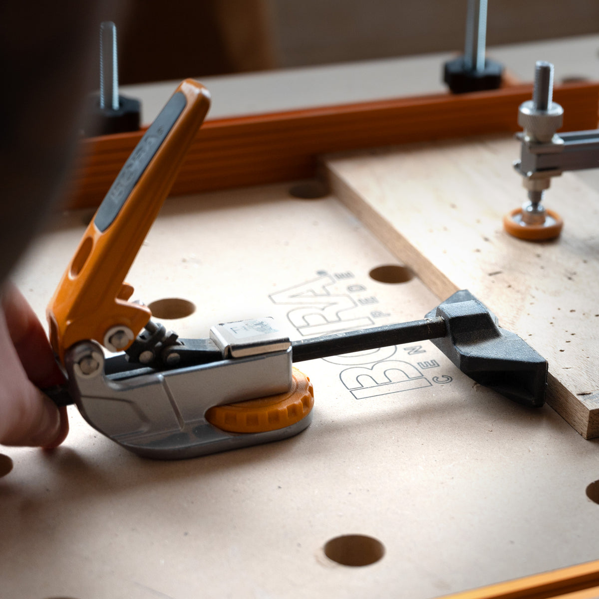 BORA Tool Dog Hole Auto Adjust Inline Toggle Clamp in action on workbench