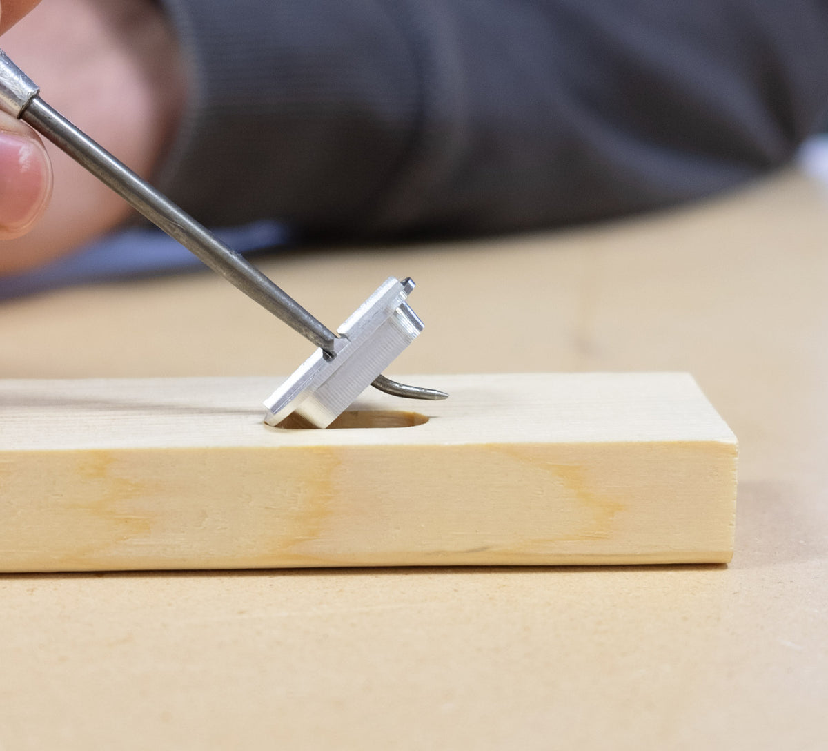 Person retrieving FastCap metal Mortise Marker from mortise in timber with metal tool