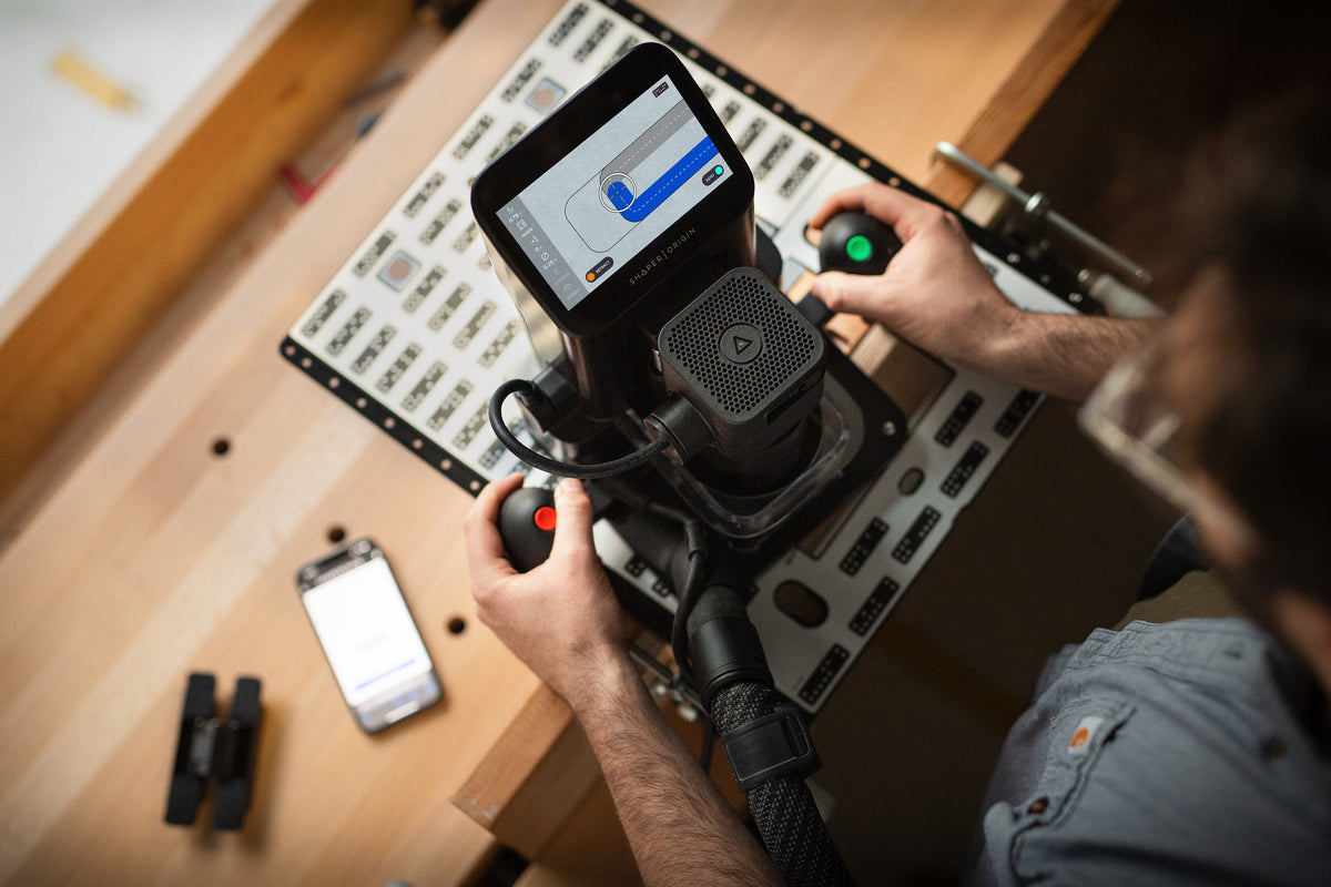 Shaper Plate universal template in use with Shaper Origin Handheld CNC Router at a woodworking site
