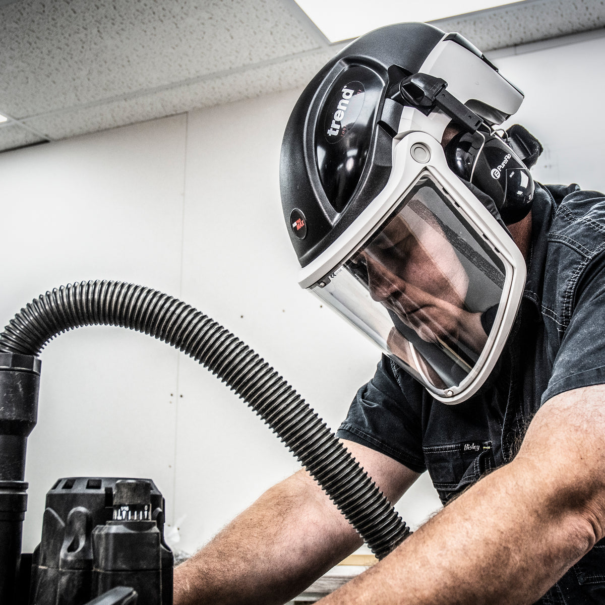 Trend Air Pro Max Ear Defenders attached to Airshield Pro respirator face shield in woodworking workshop