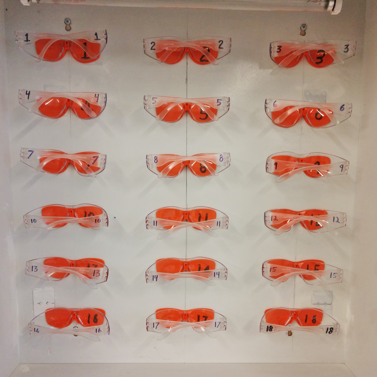 FastCap Eye Mount for CatEyes Safety Glasses being attached to a smooth surface using VHB mounting adhesive