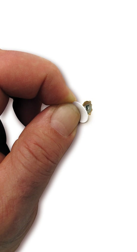 FastCap white PVC self-adhesive screw cover caps in mini box of 265 caps on wood surface