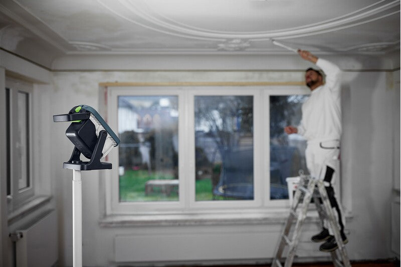 Compact Festool SYSLITE KBS C cordless construction light in use on a construction site, providing 5000 lumens brightness