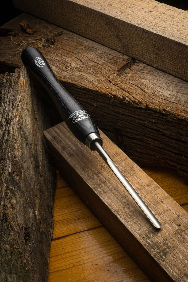 Crown 10mm Spindle Gouge M2 Cryogenic Steel Woodturning Tool resting on a wooden lathe tool rest