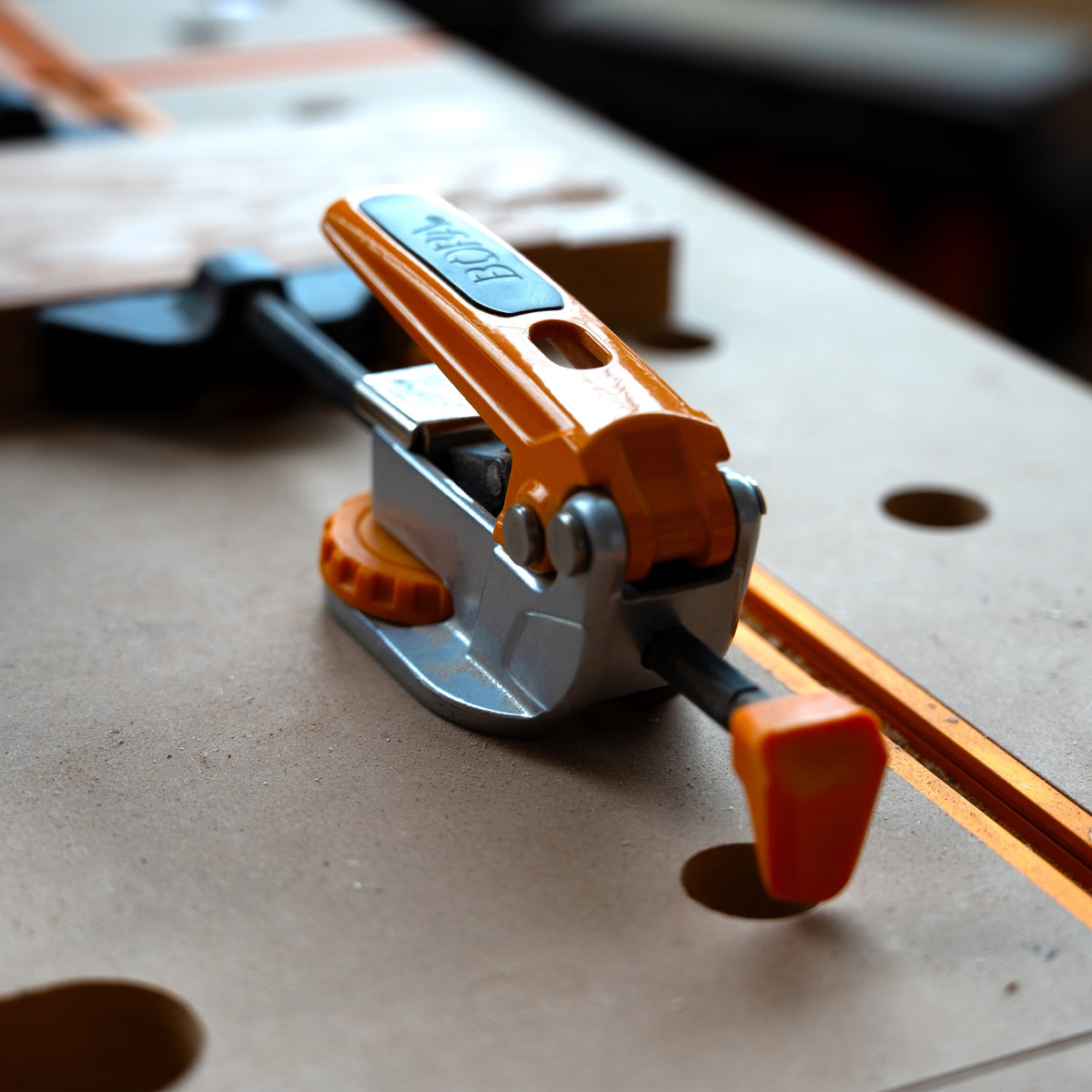 BORA Tool Dog Hole Auto Adjust Inline Toggle Clamp 90mm Reach in use on workbench