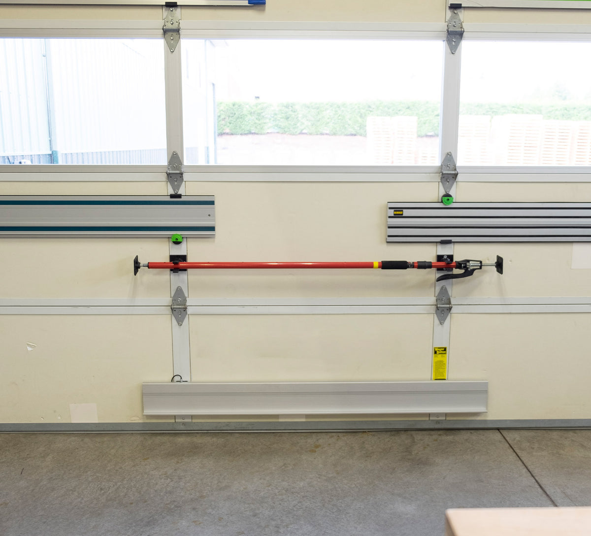 FastCap 3rd Hand Rack Mountable Holder being installed on a workshop wall