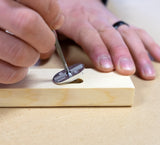 Person retrieving FastCap metal Mortise Marker from mortise in timber with metal tool