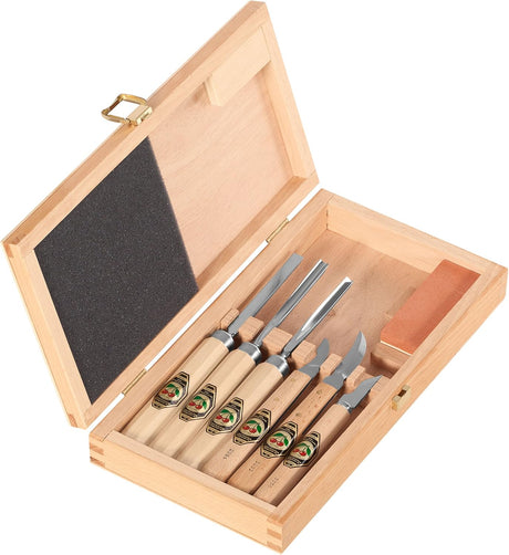 Set of six wooden carving tools and sharpening stone with branded labels in a wooden case.