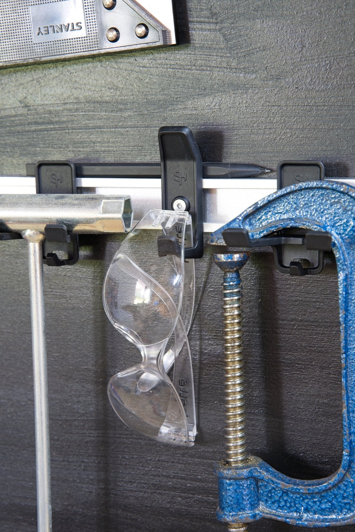 Superhooks Starter Bundle 15-Pieces Black Modular Tool Wall Hooks in use on a wall with tools hanging
