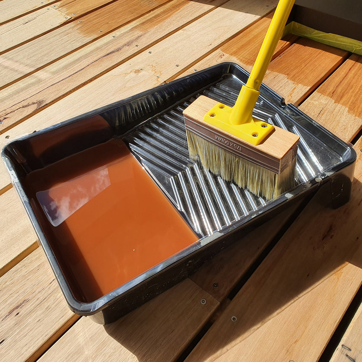 UniPro Jumbo Decking Brush applying coating between deck boards
